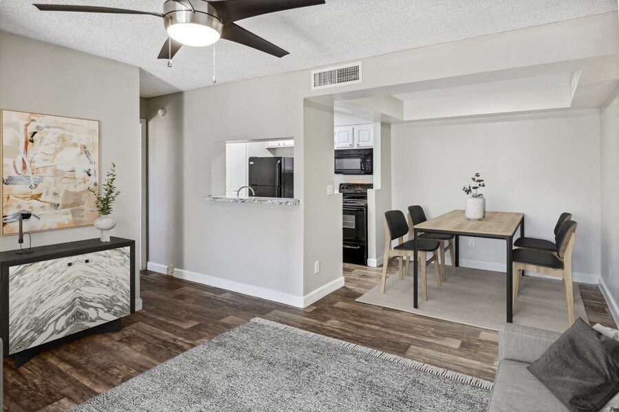a living and dining area with a ceiling fan and hardwood floors